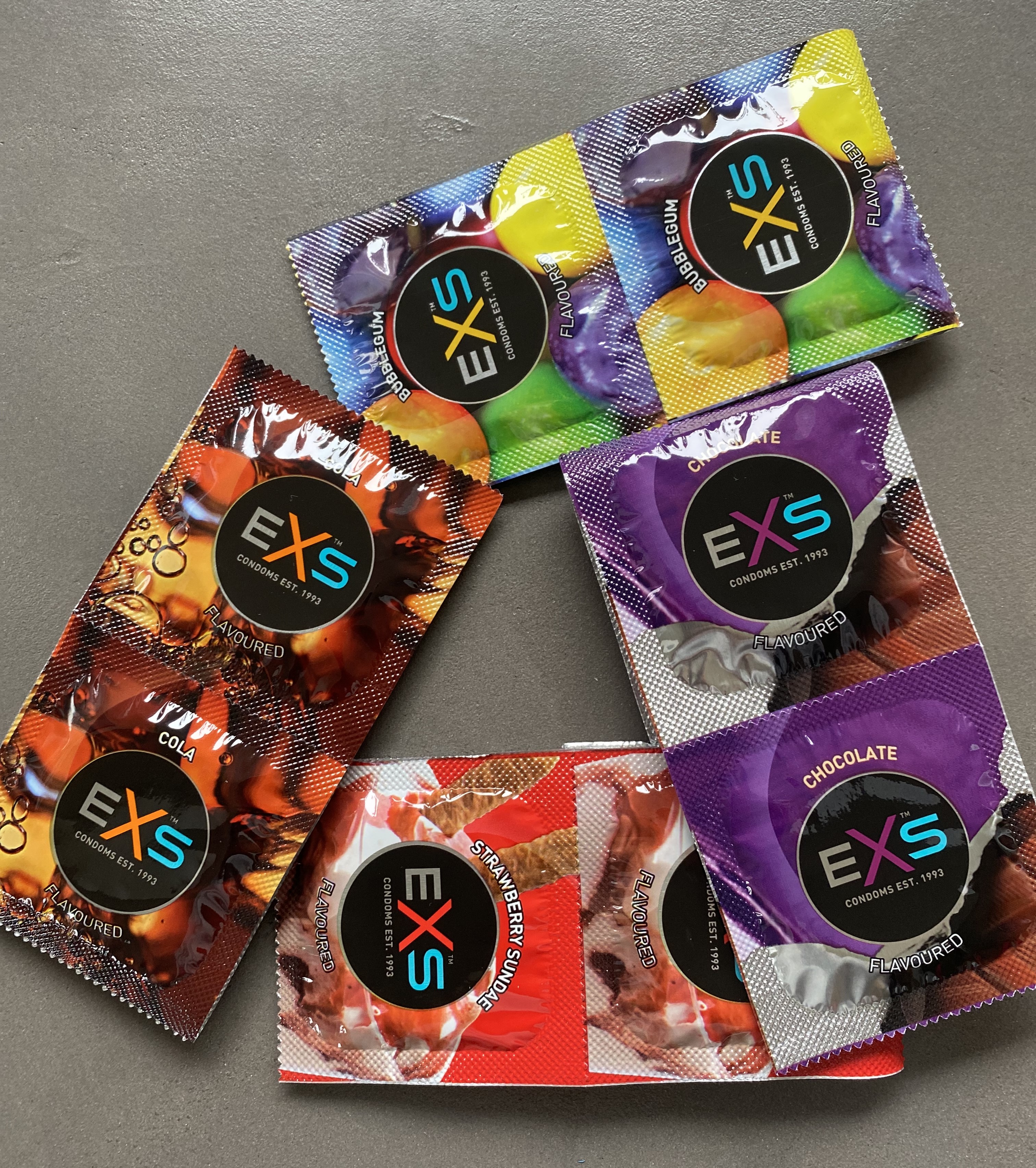 ĮVAIRIŲ SKONIŲ IR KVAPŲ PREZERVATYVŲ RINKINYS "EXS MIXED FLAVOURED" - 400 VNT.  
"EXS Mixed Flavoured" - prezervatyvų rinkinys  sudarytas iš skirtingą skonį bei kvapą turinčių prezervatyvų: 
"EXS Crazy Cola"  (100 vnt.) - kolos skonio ir kvapo prezervatyvai; 
"EXS Strawberry Sundae"  (100 vnt.) - braškinių ledų skonio ir kvapo prezervatyvai; 
"EXS Hot Chocolate"  (100 vnt.) - šokolado skonio ir kvapo prezervatyvai; 
"EXS Bubblegum" (100 vnt.) - kramtomosios gumos skonio ir kvapo prezervatyvai. 
Šie prezervatyvai  idealiai tinka oraliniam, vaginaliniam ir analiniam seksui  ir  yra griežtai  išbandyti pagal Europos ir Britų standartų instituto (BSI) standartus. 
Visų jų plotis:  56 mm 
Prieš užsidėdami prezervatyvą įsitikinkite, kad jūsų varpa neliečia partnerio lytinių organų srities – sperma iš varpos gali išeiti dar prieš pilną ejakuliaciją.  
*Atminkite, kad nė viena kontraceptinė priemonė nėra 100 % veiksminga nuo nėštumo, ŽIV ar lytiškai plintančių infekcijų.  